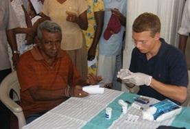 Volunteer Medicine & Healthcare Physiotherapy interns in Sri Lanka watch as a local medical professional works with a child with mobility impairments.